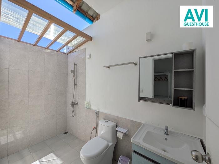 Semi-open bathroom with rain shower under a skylight